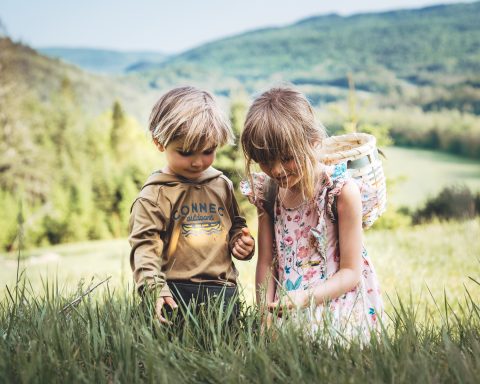 deux enfants dans un champ verdoyant