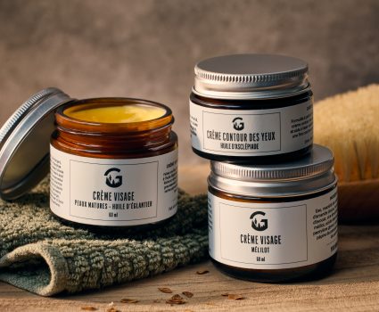 Trois pots de crème visage et contour des yeux sur une planche de bois