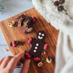 Bonhomme en chocolat sur planche en bois avec morceaux de chocolat et noisettes