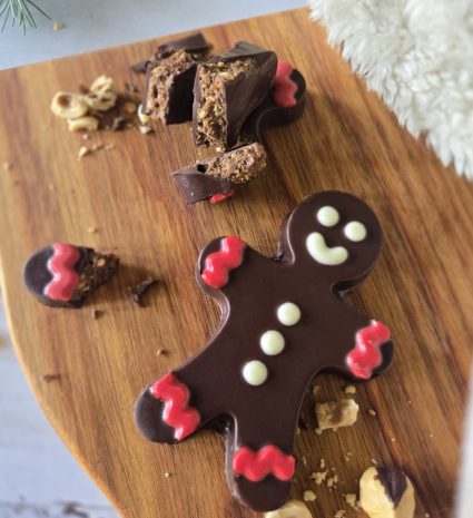 Bonhomme en chocolat sur planche en bois avec friandises