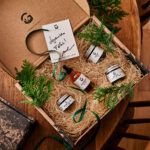 Coffret de pots et flacons avec branches de conifère sur une table en bois