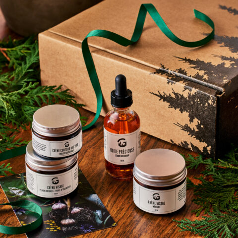 Coffret de soins avec pots de crème et huile précieuse sur une table de bois