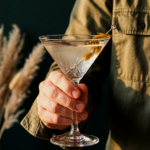 Verre à martini avec garniture végétale jaune tenu à la main